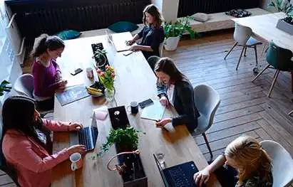 Colleagues working on laptops around a shared table